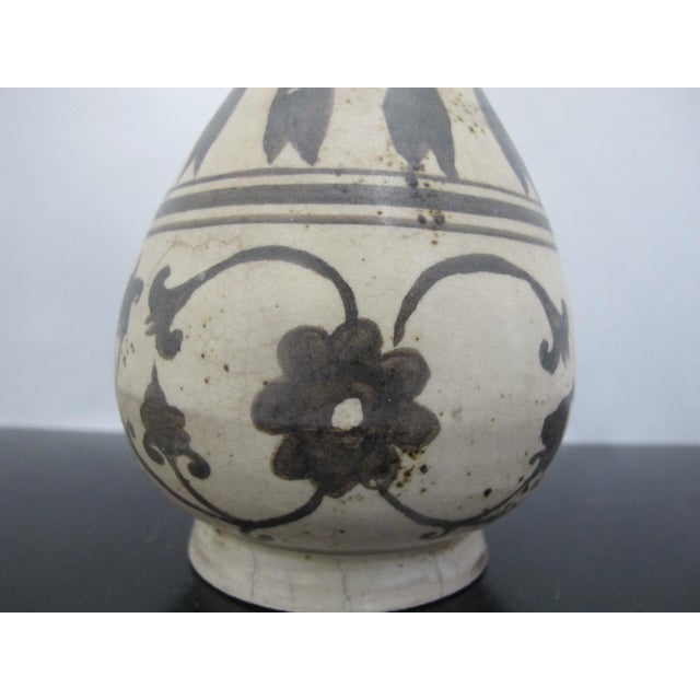 Chinese Cizhou Kiln pear-shaped pottery vase featuring floral designs on a cream white base. Features a distinctive pear-...