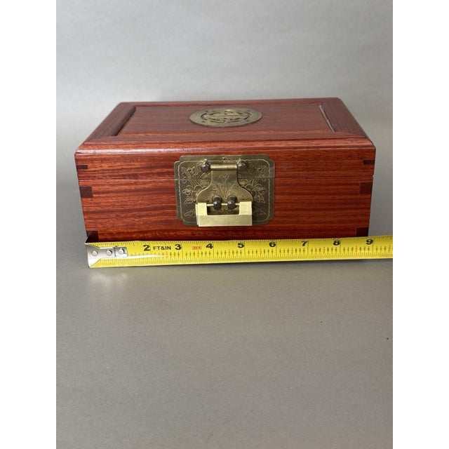 This Chinese Asian Wooden Jewelry Box is a vintage trinket chest with a brass and wood exterior and red silk lining. It...