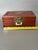 This Chinese Asian Wooden Jewelry Box is a vintage trinket chest with a brass and wood exterior and red silk lining. It...