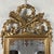 Carved Empire Style Gilded Mirror. Gilded mirror in carved wood with gilt leaf, exquisitely crafted, with a carved cornice...