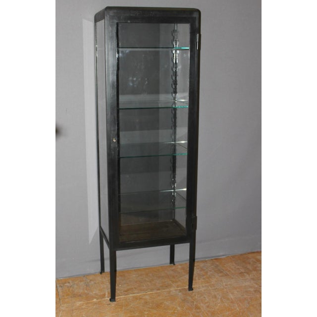 Black lacquered iron display case, glazed on three sides, four adjustable shelves, interior dimensions 50 cm long and 35.5...