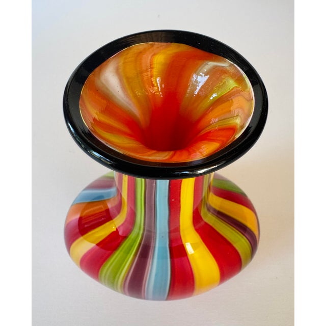 Hand-blown Badash art glass vase with multicolored vertical stripes and a black cased rim. The bold rainbow palette and...