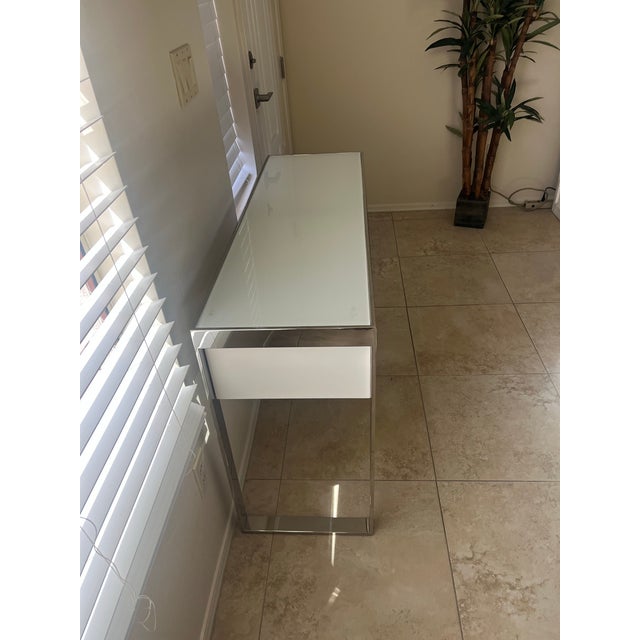 This is an exquisite mid-century modern aesthetic console table with polished steel and white glass in style of the...