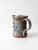 Vintage handmade studio pottery pitcher finished in a soft gray glaze with expressive cobalt brushwork and a warm exposed...