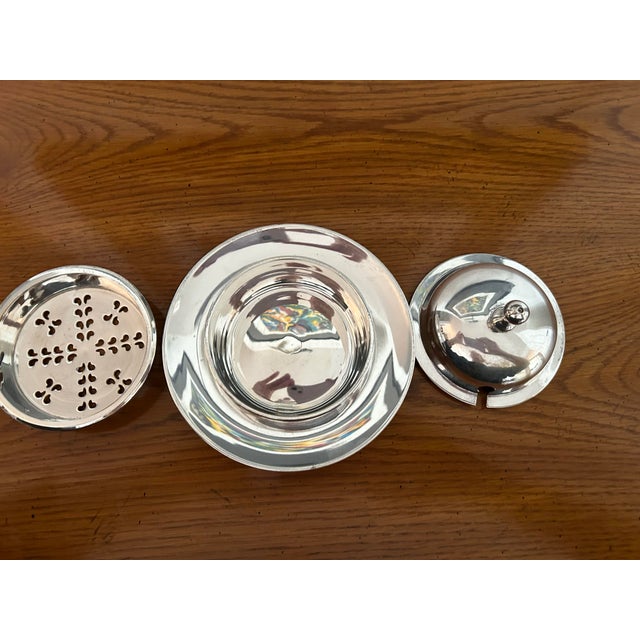 Round silver plate butter dish. You could change insert to glass and also use as caviar serving dish. Little strainer insert.