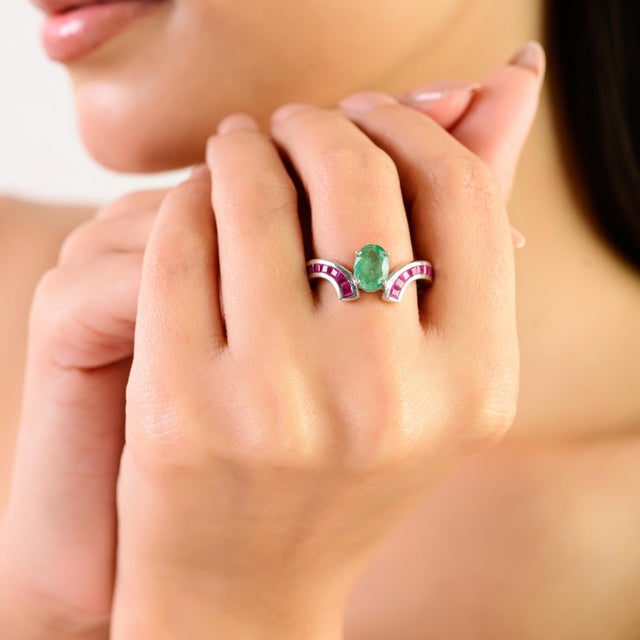 This modern crossover ring is crafted in 925 sterling silver and features a striking inlay of emerald and ruby gemstones....