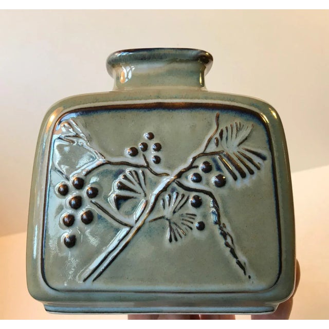 This rare Danish stoneware vase manufactured by Bing & Grøndahl/B&G in Copenhagen, Denmark is decorated with berries and...