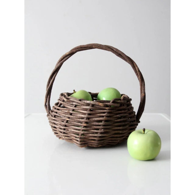This is a vintage rustic wicker basket. The woven twig basket features a twisted top handle. A lovely flower basket or for...