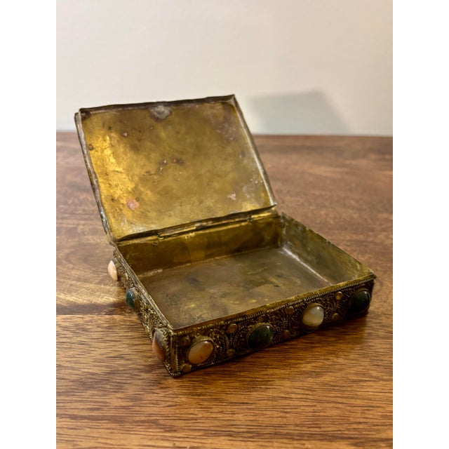 A richly detailed antique Tibetan jewelry or keepsake box featuring intricate hand-worked brass filigree and cabochon...