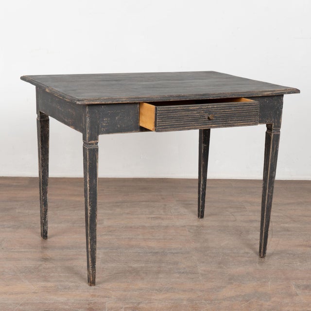 Antique Swedish Gustavian Black Painted Side Table With Drawer. Tapered legs and horizontal fluted carving along single...