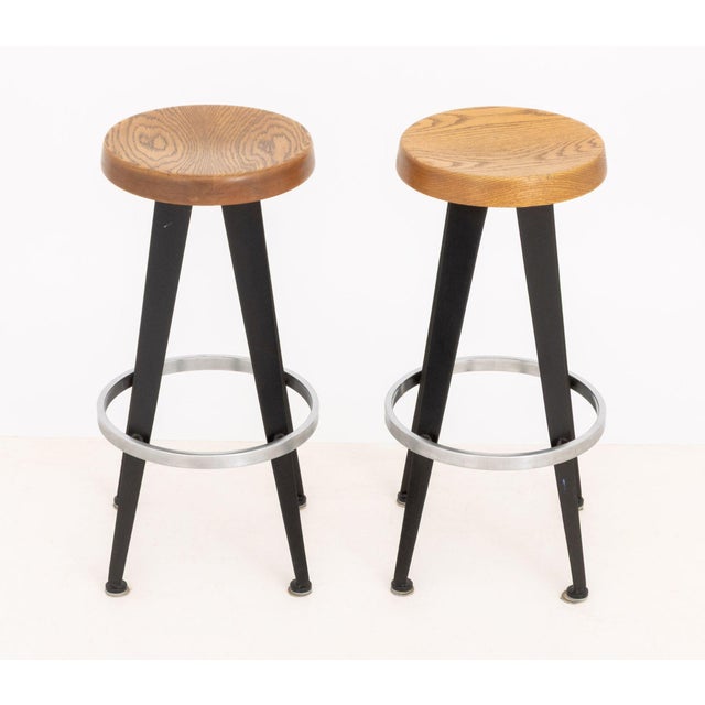 Pair of After Jean Prouve Circular Oak Seat Bar Stools, on black patinated metal and aluminum bases. 28.25" H x 14.5"...