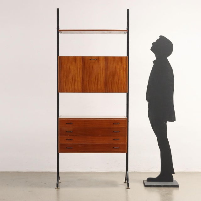Bookcase with storage compartments, drawers and flap in mahogany veneered wood, enamelled metal structure. This piece is...
