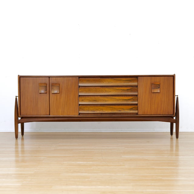 This striking credenza was designed and produced by 'Elliots of Newbury' of Berkshire, England during the 1960s. A...
