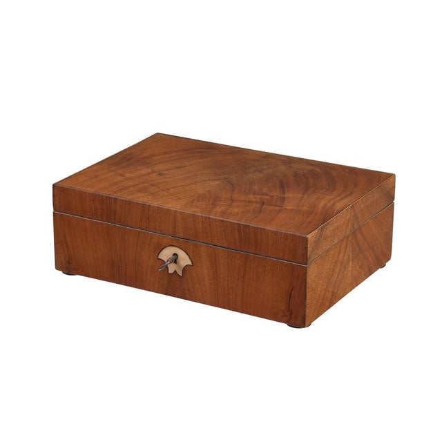 Box Biedermeier period, circa 1830, solid and veneered walnut, mirrored veneer on the lid, inlaid bone escutcheon, lined...