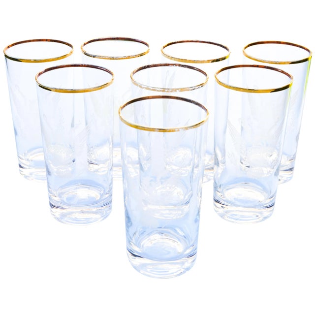 Set of eight midcentury gold-rimmed tall glasses with ornate itching pattern. No maker's mark. This beautiful set ships...