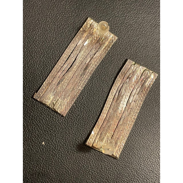 These sterling silver drop earrings feature a wide, segmented ribbon design with alternating textured and polished link...