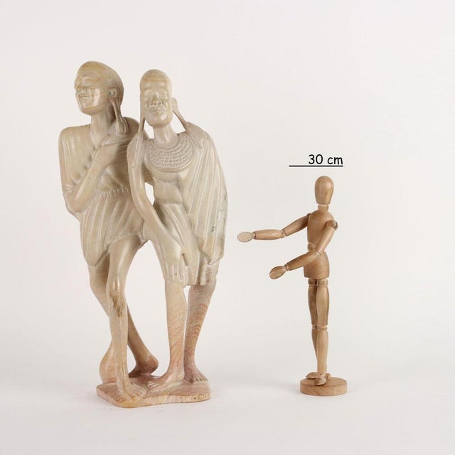 Stone sculpture depicting a pair of African figures. This piece is attributed to the mentioned designer/maker. It has no...