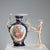 A pair of cobalt blue porcelain vases with hand-painted floral decorations enclosed in gold reserves. Elaborate handles on...