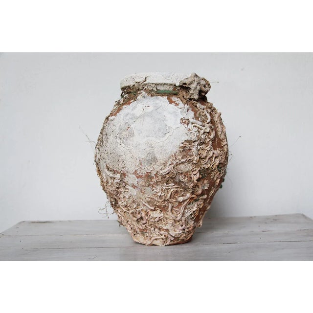 An hand made terracotta pot originally submerged under sea and used as a trap for an individual octopus. This pot has a...