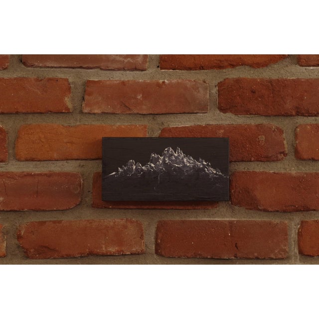 In "Melted," jagged peaks rise dramatically against a deep, dark background, evoking a sense of raw, untamed nature. The...