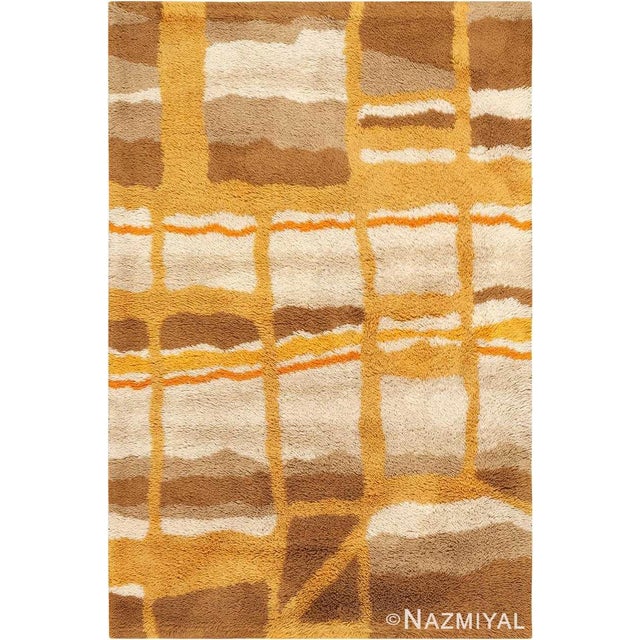 Layered geometric figures rendered in warm earthy colors decorate this abstract vintage Swedish deco rug creating an...