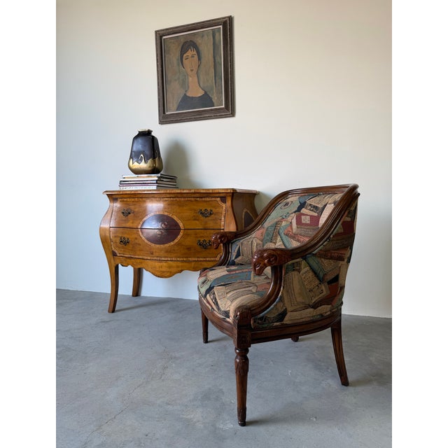 Elegant vintage club chair inspired by the French Empire style, featuring beautifully carved wooden arms adorned with...