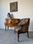 Elegant vintage club chair inspired by the French Empire style, featuring beautifully carved wooden arms adorned with...