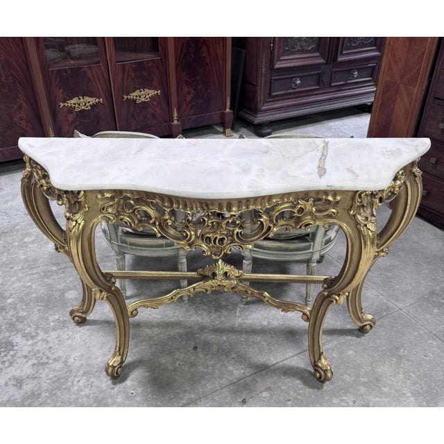 A very elegant carved and gilded wood console table in the louis xv style, featuring a rich rocaille decoration. the...
