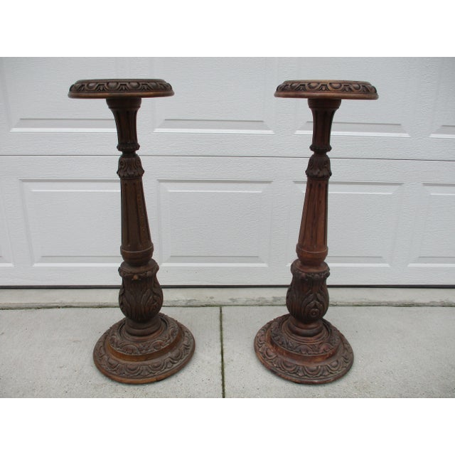 A great looking pair of baroque style wooden plant stands or torchieres. The carved details on this pair of pedestal style...