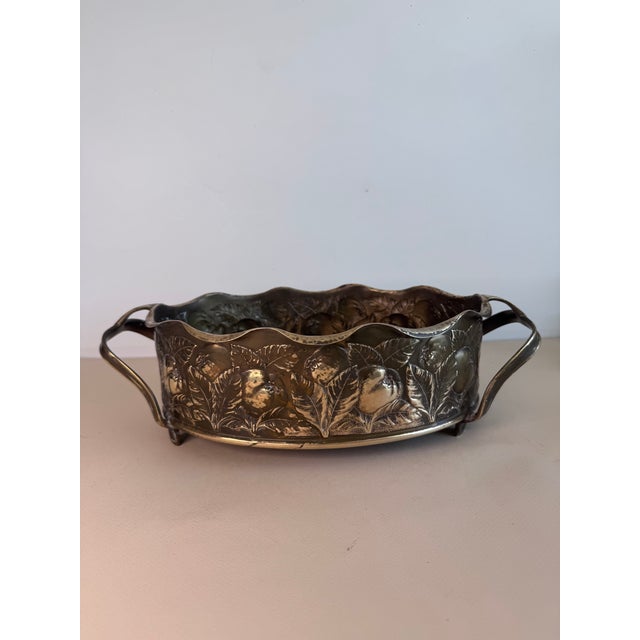 A beautiful piece surrounded with an apple and foliage relief. The handles hint at Art Nouveau design and give way to...