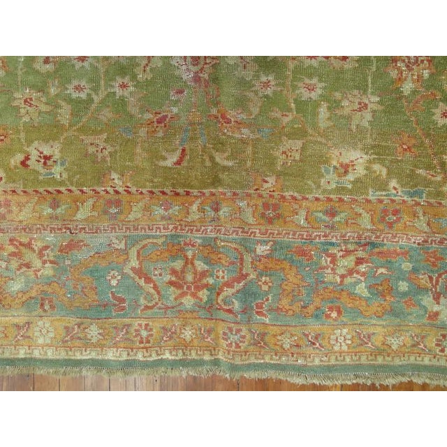 A room size fine antique Turkish Oushak featuring a green background 8'9'' x 11'3''