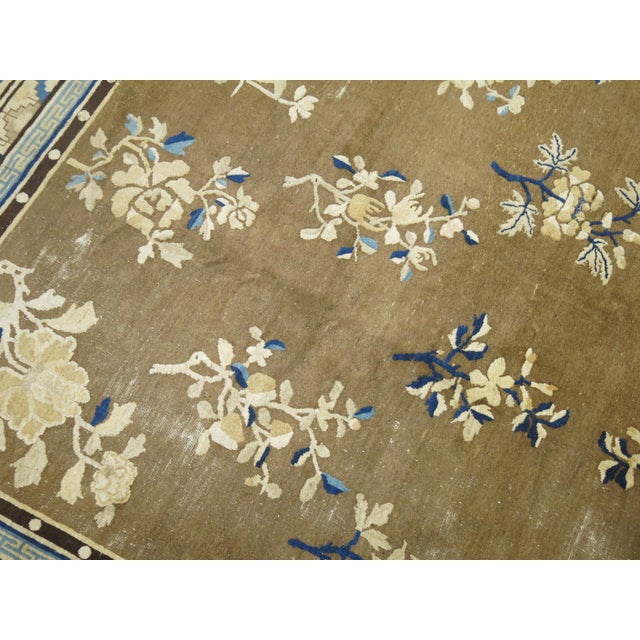 An early 20th century rare original size Chinese square rug in predominant shades of brown. The wool is very soft and all...
