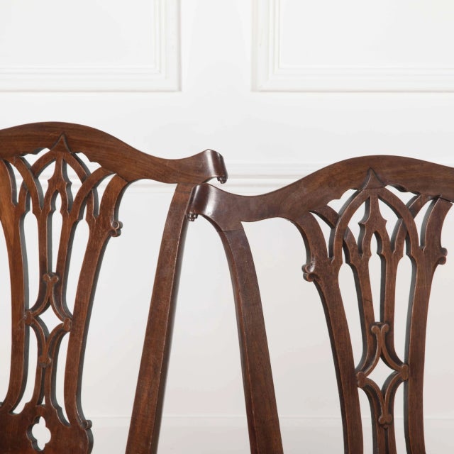 An unusual pair of 18th Century Mahogany Side Chairs. The top rails with scroll ears and central carved splats of...