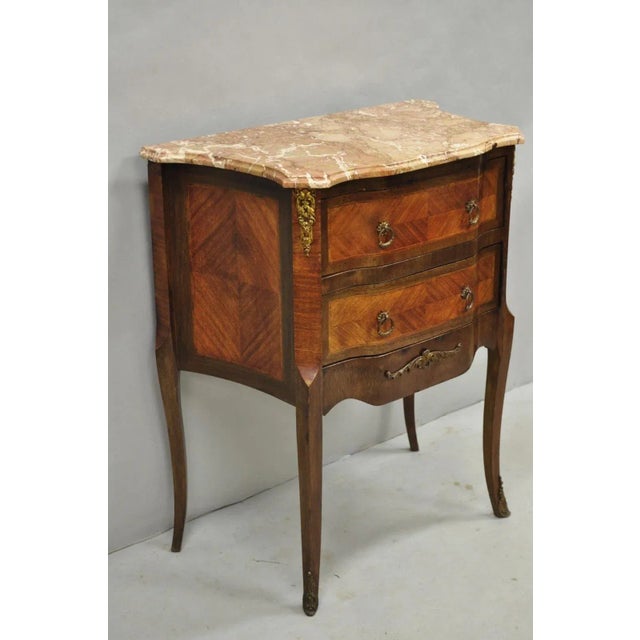 Antique French Louis XV Style Marquetry Inlay Marble Top Bombe Side Table. Item features 2 dovetailed drawers, rouge...