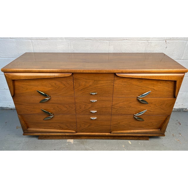 A classic mid-century walnut dresser from Kent Coffey’s “The Barnsley” line, featuring clean lines and a timeless...