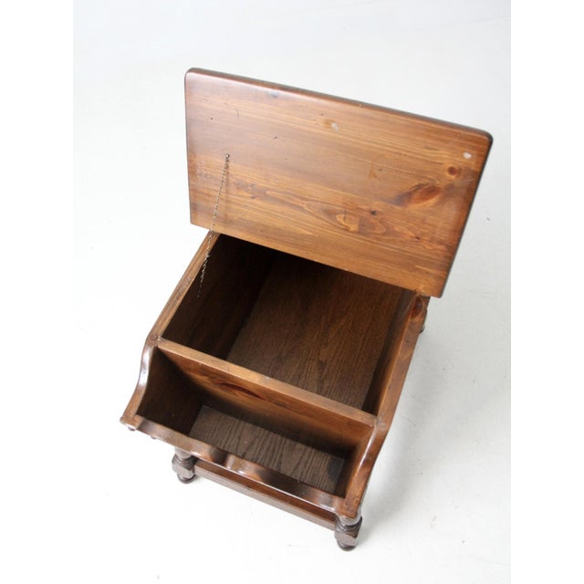 This vintage mid-century magazine rack end table features a Colonial Revival–inspired design with turned legs, a lift-top...