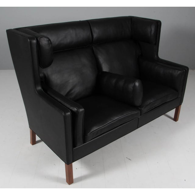 Børge Mogensen new upholstered kupe sofa with black elegance leather. Legs of teak. Model 2292, made by Fredericia...