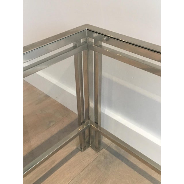 This modernist chrome coffee table with triple feet is made of chrome with 2 glass shelves. This is a French work. Circa 1970