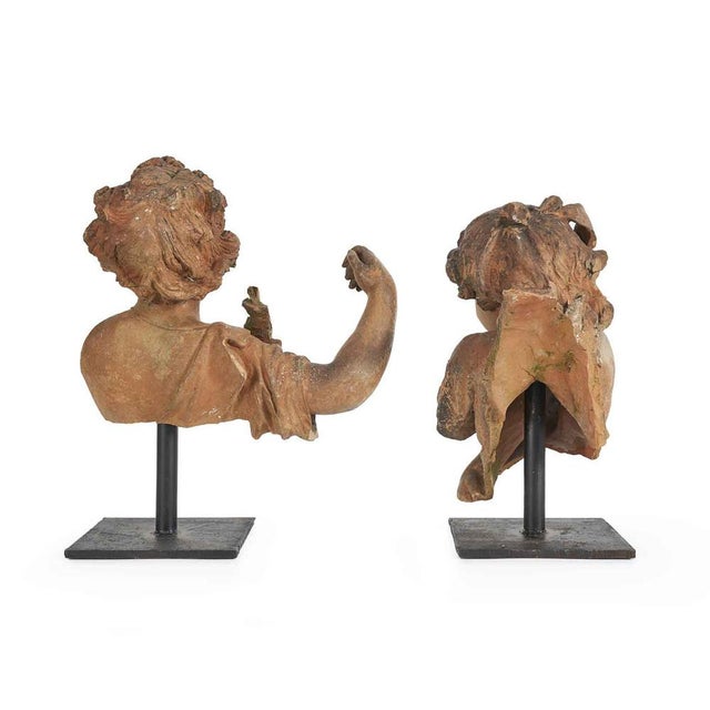 A pair of terracotta children from the late 19th century, likely part of a larger sculptural group, perhaps a fountain....