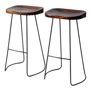 Pair of Vintage Sculpted Wood Saddle Seat Bar Stools With Black Iron Bases For Sale