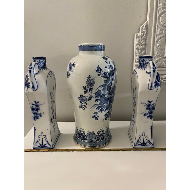 Early 20th Century Delft Set consisting of rounded middle vase with hand painted windmill scene, flanked on both sides by...