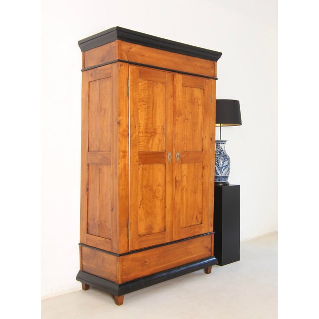 A mid-19th century German two-door wardrobe or hall cupboard. Crafted from solid cherry wood. Restored to a ready-to-use...