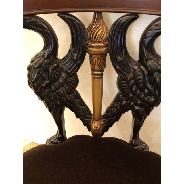 Dramatic carved wood armchair in mahogany, ebonized wood and gilded elements having elegant swan motif with arms that are...