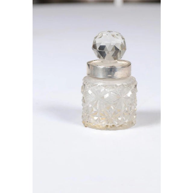 A small English crystal jug from the 19th century, with silver neck and round faceted stopper. Born in England during the...
