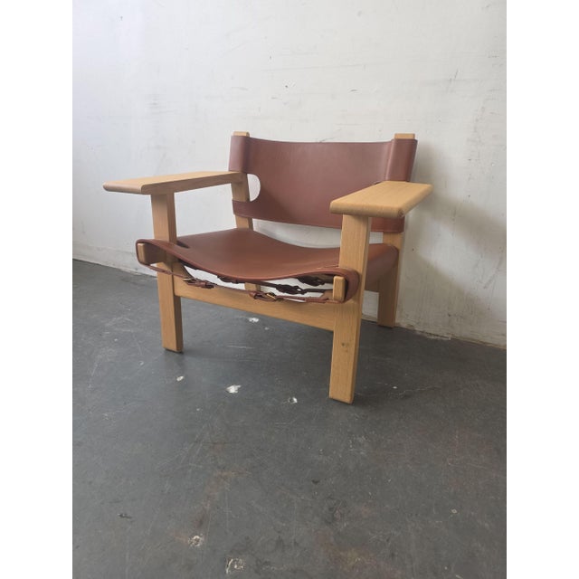This Fredericia Furniture Spanish Chair is perfect for your lounge. It features sturdy oak wood and thick, cognac-colored...