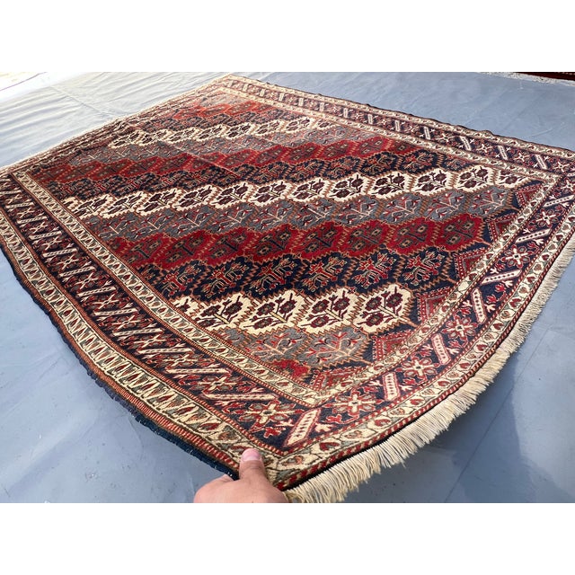 A captivating antique Caucasian Shirvan tribal rug in the classic all-over blossom lattice format — the entire field is...