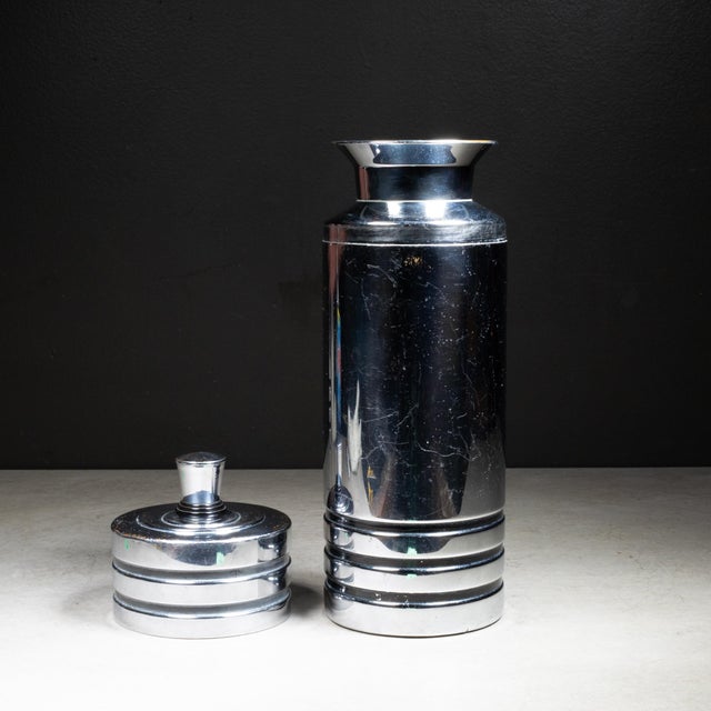 ABOUT Art Deco chromed copper cocktail shaker with black enamel bands and Bakelite collar. Cap lifts to reveal a...