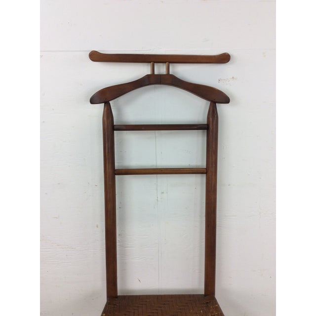 This mid century modern gentleman’s valet features hardwood construction, original walnut finish, hanger back design with...