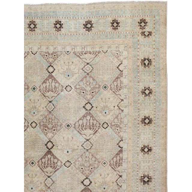 This mid-20th-century Persian Kashan carpet presents a refined allover lattice composition across a soft ivory and pale...