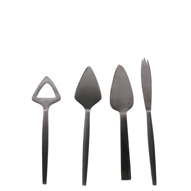 Four stainless steel serving pieces by Kalmar to include three knives, and one bottle opener. All pieces are in very good,...